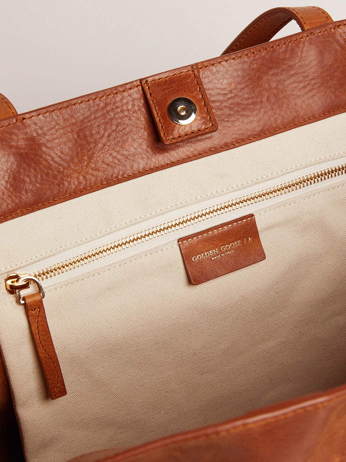 Golden Goose Pasadena Bag in tan-colored glossy hammered leather with gold logo on the front