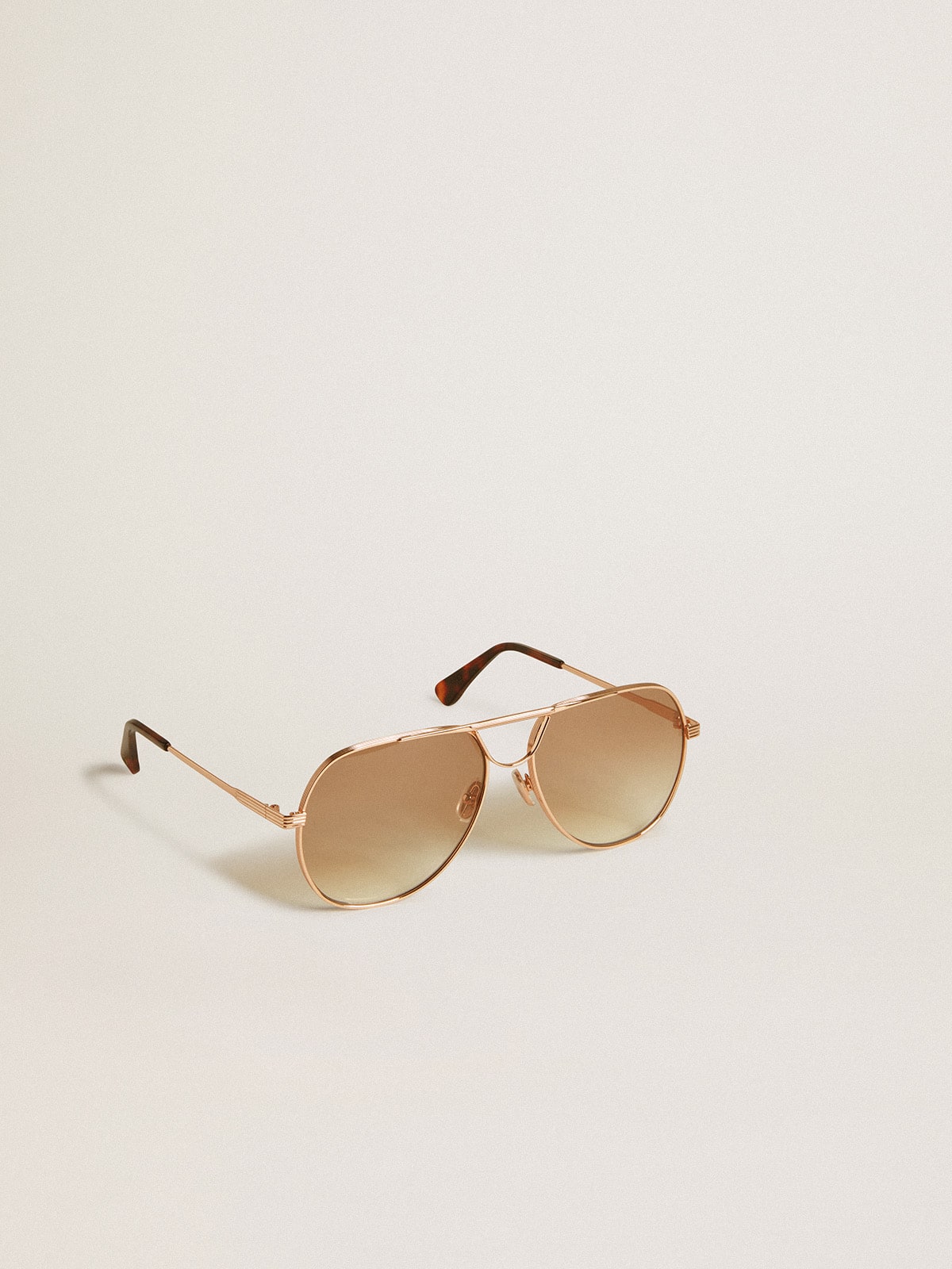 Golden Goose Aviator style sunglasses with rose-gold frame and honey-colored lenses